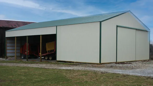 Cream barn with a green roof and trim, a wide sliding door and an open bay holding equipment