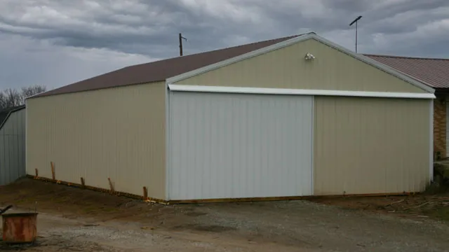 Cream machine shed with a maroon roof and a wide sliding door