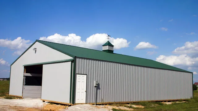 Cream barn with a green roof, a cupola and an open equipment bay