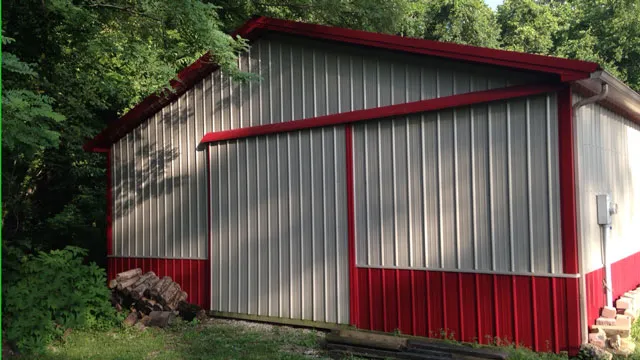 Silver barn with red trim and red wainscot on a wooded lot