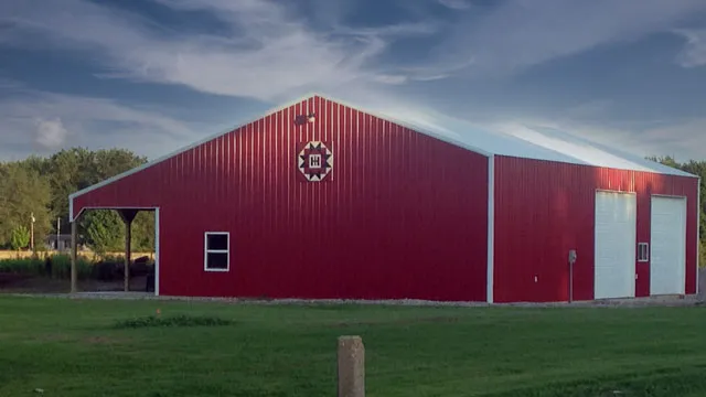 Red barn with a white door, windows and a painted barn quilt on the gable