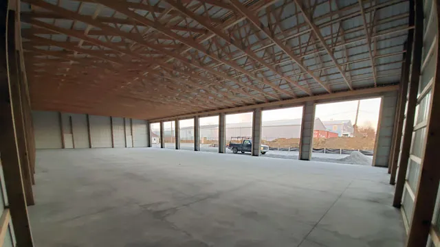 Inside a wide commercial building, looking down the open bays toward the doors
