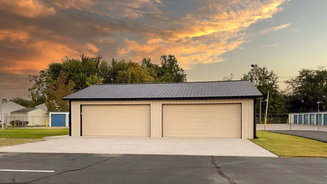 Cream commercial garage with two white overhead doors on a paved lot