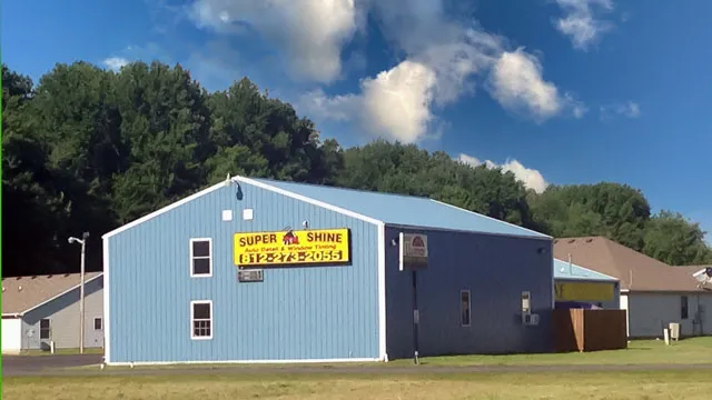 Blue commercial building with a yellow sign and windows