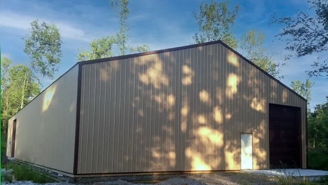 Dark gray commercial building with an overhead door under dappled shade
