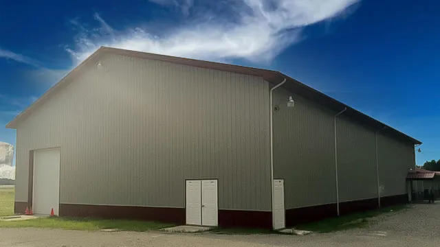 Cream commercial building with maroon wainscot and a walk door
