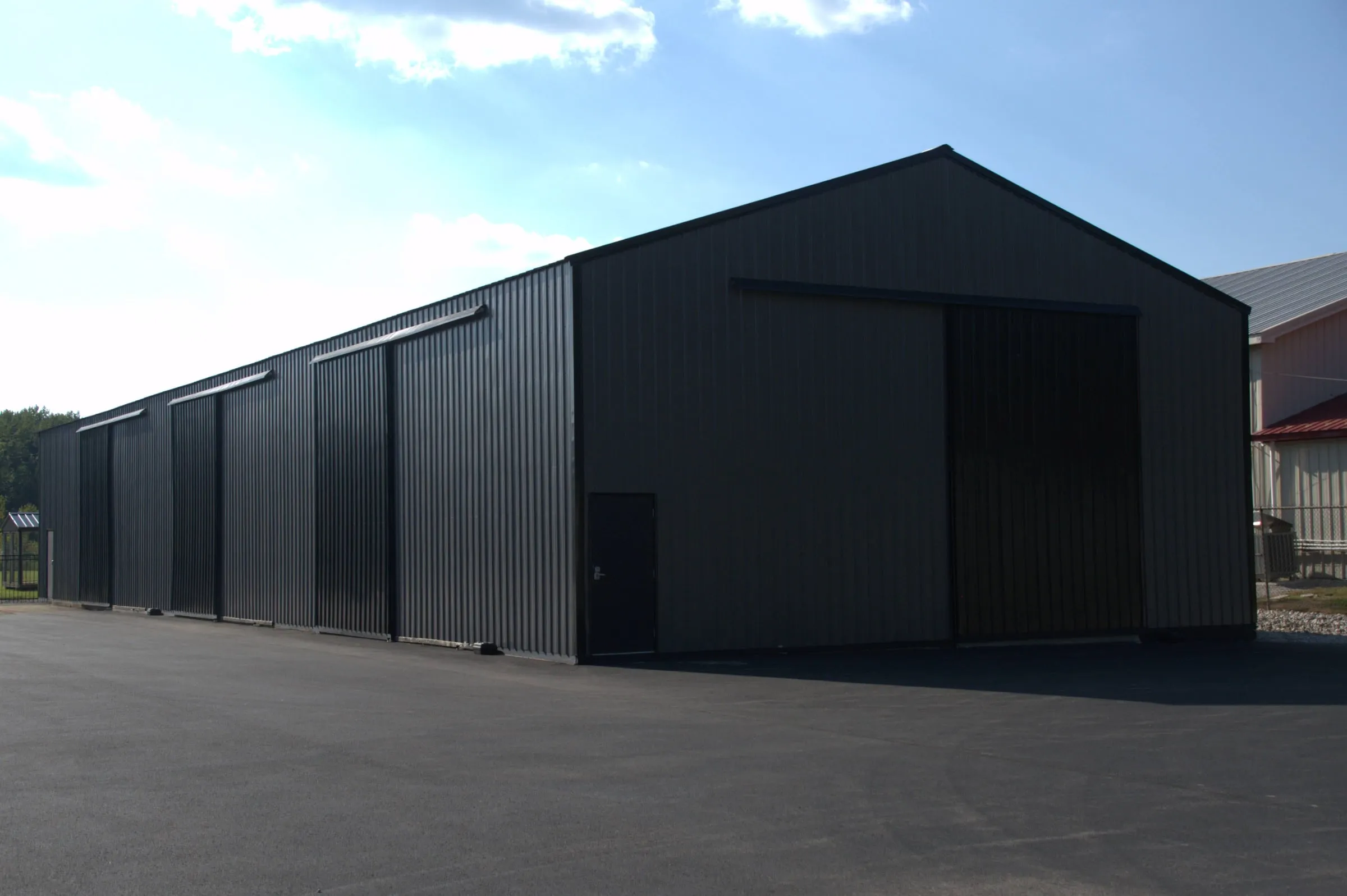 Long gray building with a large sliding door on the end