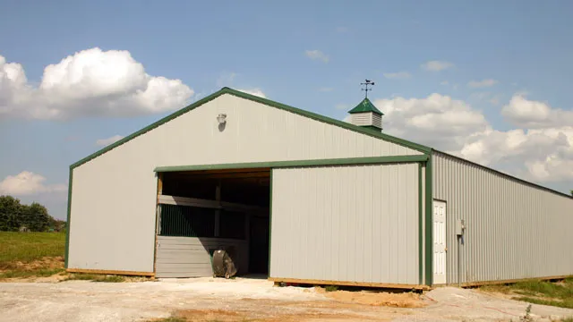 Cream barn with green trim, a cupola and a wide sliding door