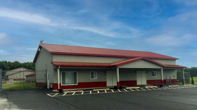 Cream building with a red roof, red wainscot and a covered walkway