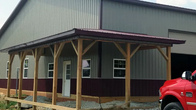 Gray building with maroon wainscot and a timber-post porch running past the windows