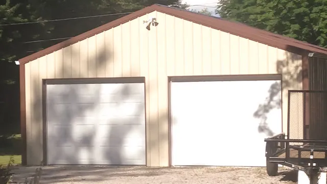 Tan shop with two white overhead doors and a utility trailer alongside