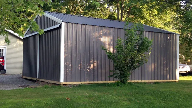 Dark charcoal building with a light gray roof standing on gravel