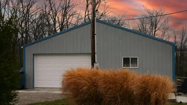 Gray shop with blue trim and a white overhead door at sunset