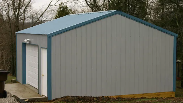 Gray shop with a blue roof and trim and one white overhead door