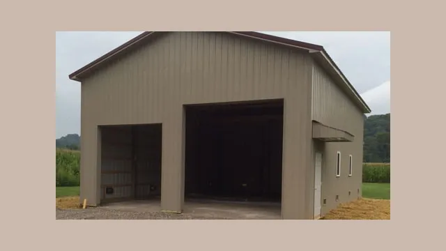 Tan building with a wide open bay beside an overhead door, standing in a field