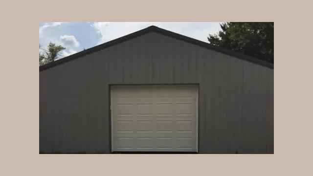 Dark gray building with a single white overhead door