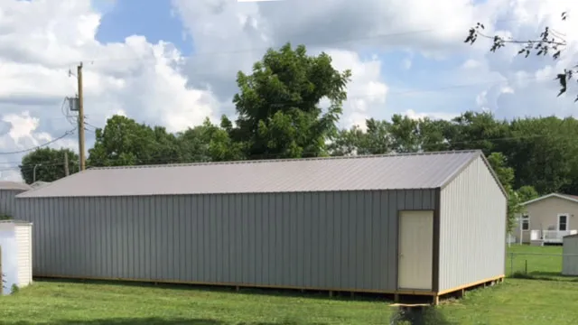 Long gray building with a lighter gray roof and a walk door