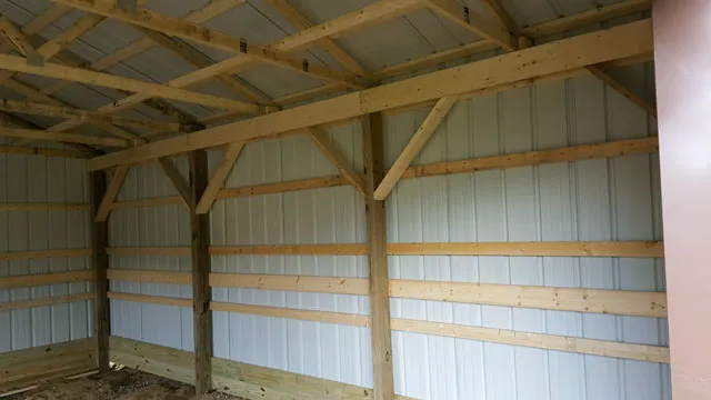 Inside a post frame shell showing the posts, trusses and white steel walls