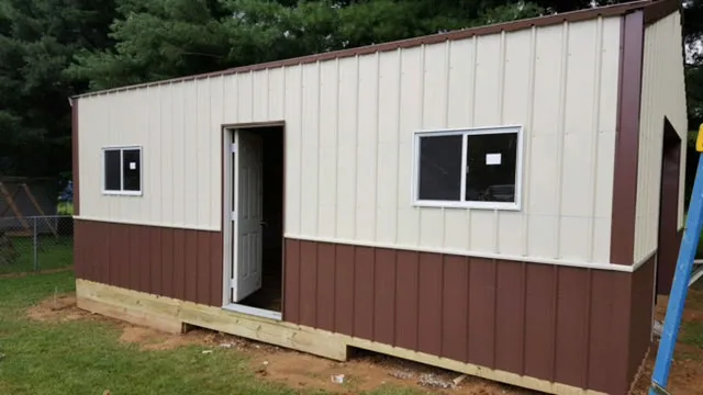 Cream building with maroon wainscot, a walk door and two windows, still under construction