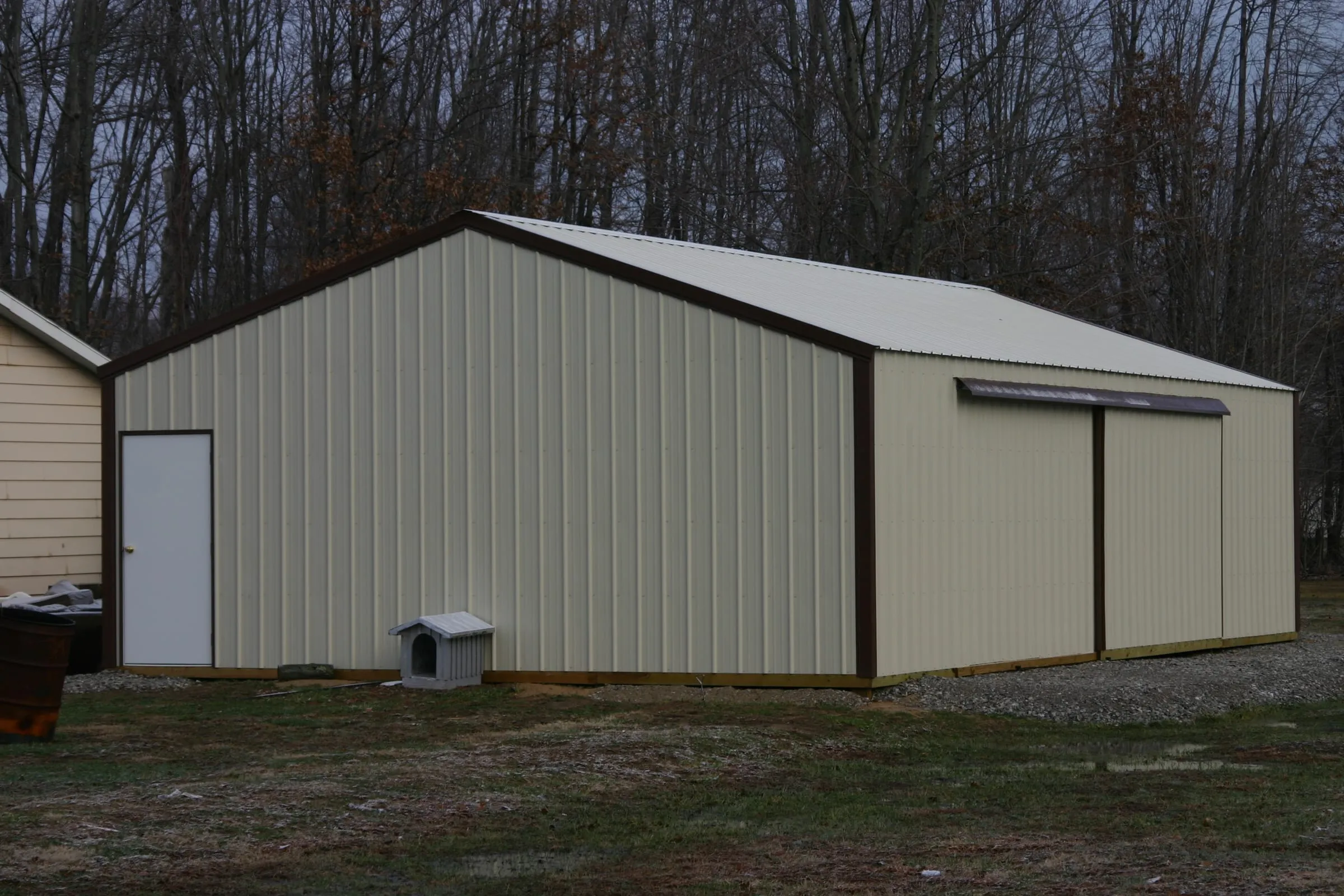 Cream building with brown trim and sliding doors, seen down the length of the wall